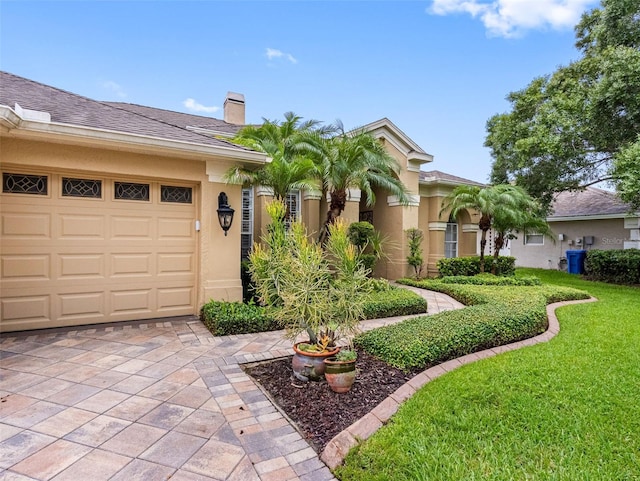12439 Bristol Commons Cir, Tampa, FL 33626 - view of front of house with stucco siding, a chimney, a front lawn, an attached garage, and driveway