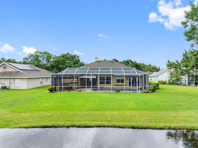 12439 Bristol Commons Cir, Tampa, FL 33626 - rear view of house featuring a lawn, a chimney, a water view, and an outdoor pool