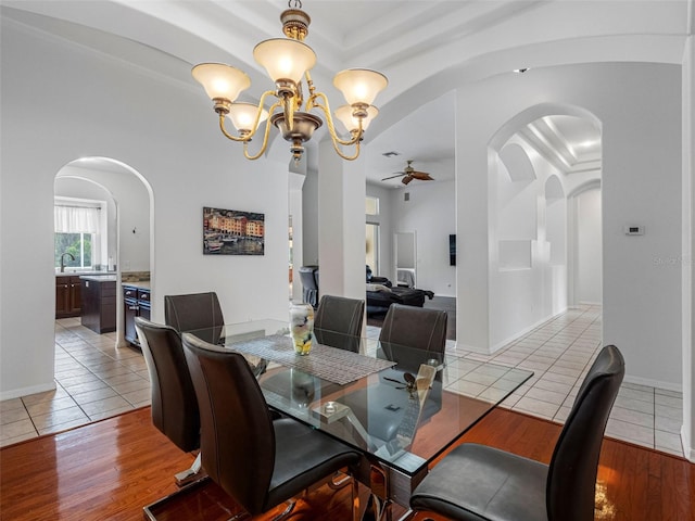 12439 Bristol Commons Cir, Tampa, FL 33626 - dining area featuring a ceiling fan, light tile patterned flooring, arched walkways, and a chandelier