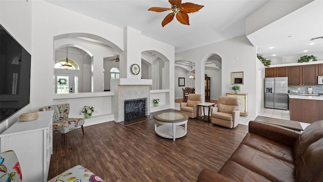 12439 Bristol Commons Cir, Tampa, FL 33626 - living area with ceiling fan, light wood-type flooring, built in features, a tile fireplace, and arched walkways