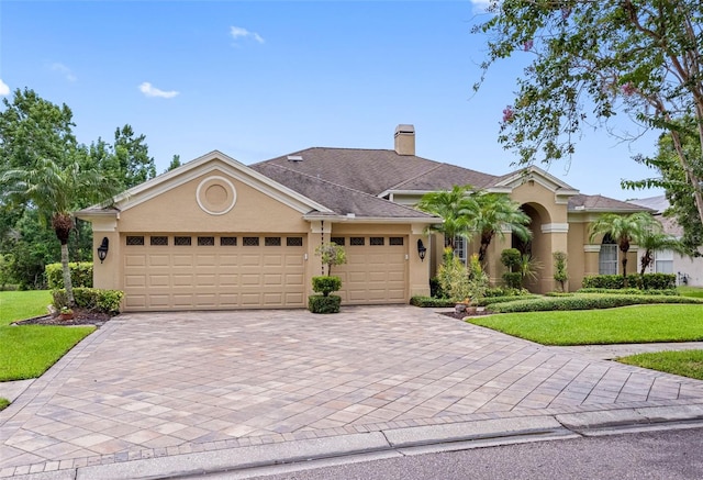 12439 Bristol Commons Cir, Tampa, FL 33626 - view of front of house featuring decorative driveway, stucco siding, an attached garage, and a front lawn