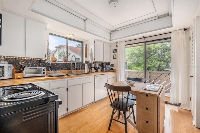 2368 Flanders Way Unit D, Safety Harbor, FL 34695 - kitchen featuring white appliances, white cabinets, light wood-style floors, and tasteful backsplash