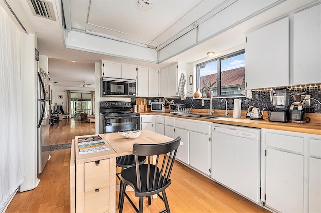 2368 Flanders Way Unit D, Safety Harbor, FL 34695 - kitchen with black appliances, light wood-type flooring, healthy amount of natural light, and tasteful backsplash