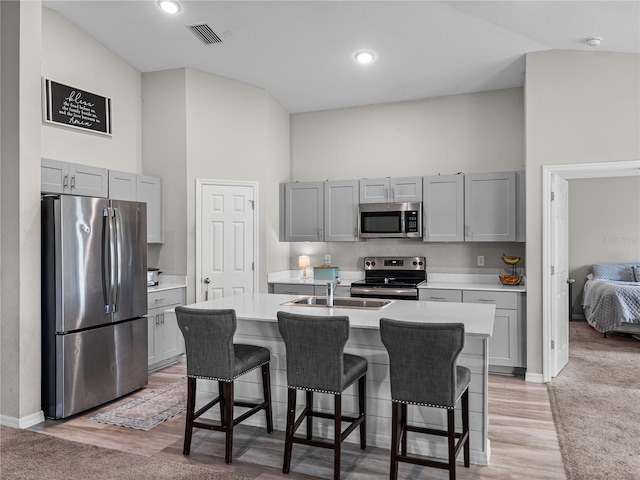 13105 Fruitville Way, Riverview, FL 33579 - kitchen featuring appliances with stainless steel finishes, high vaulted ceiling, gray cabinetry, light countertops, and a kitchen bar