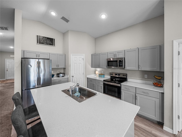 13105 Fruitville Way, Riverview, FL 33579 - kitchen featuring stainless steel appliances, gray cabinets, light countertops, a kitchen island with sink, and a breakfast bar