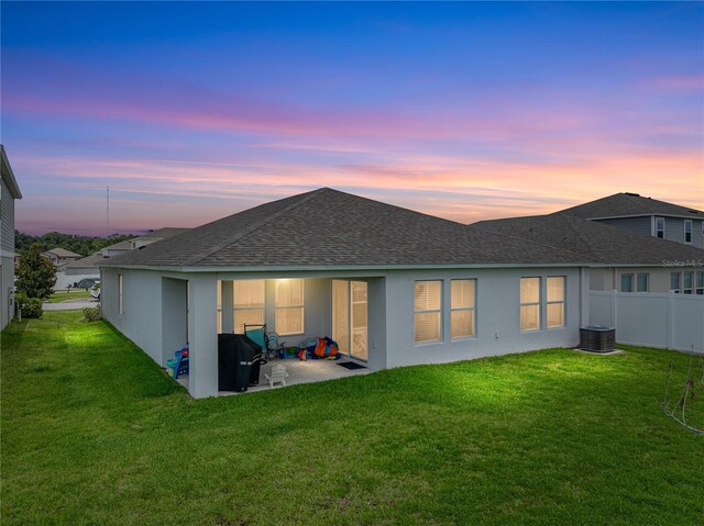 13105 Fruitville Way, Riverview, FL 33579 - back of house at dusk with a shingled roof, a patio area, and stucco siding