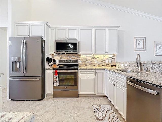 2103 SW 26th Ter, Cape Coral, FL 33914 - kitchen featuring stainless steel appliances, ornamental molding, backsplash, light stone countertops, and white cabinets