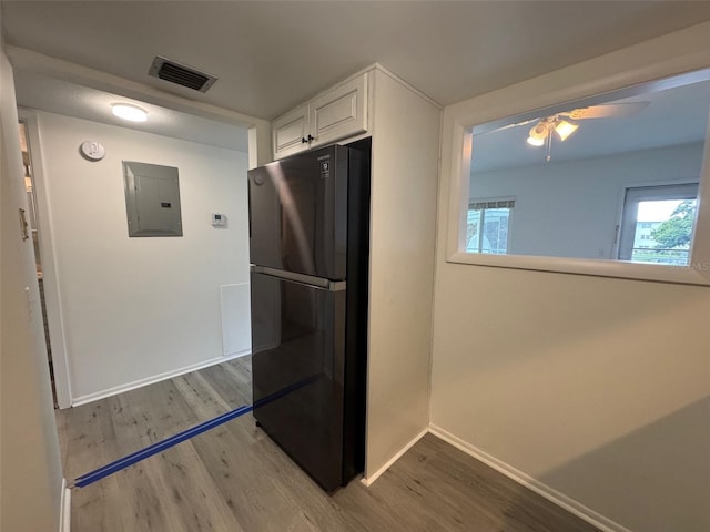 2459 Columbia Dr Unit 39, Clearwater, FL 33763 - kitchen with freestanding refrigerator, electric panel, white cabinets, light wood finished floors, and ceiling fan