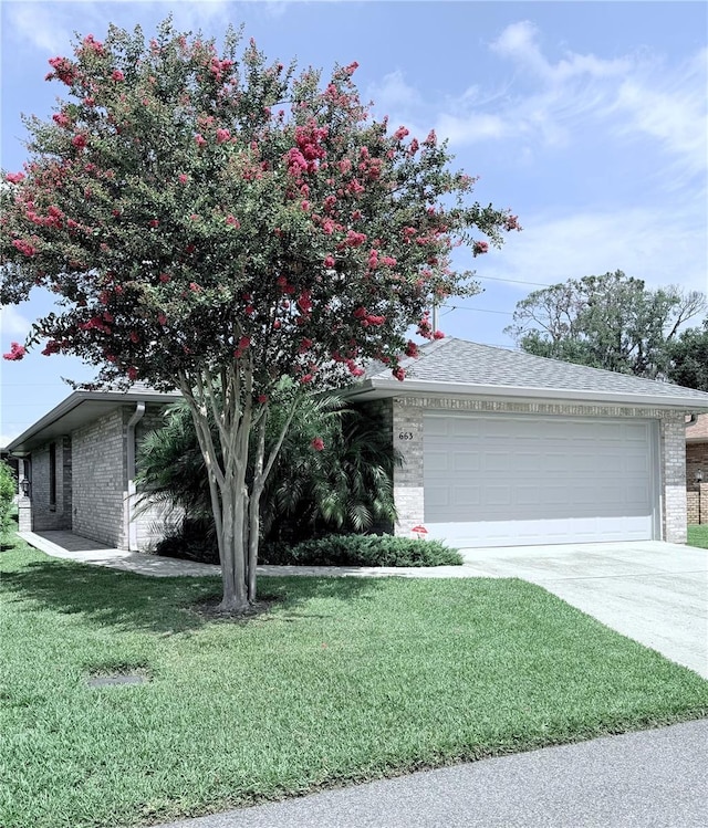 663 Jamaica Cir, Lakeland, FL 33803 - view of front facade featuring brick siding, concrete driveway, a garage, a front lawn, and roof with shingles