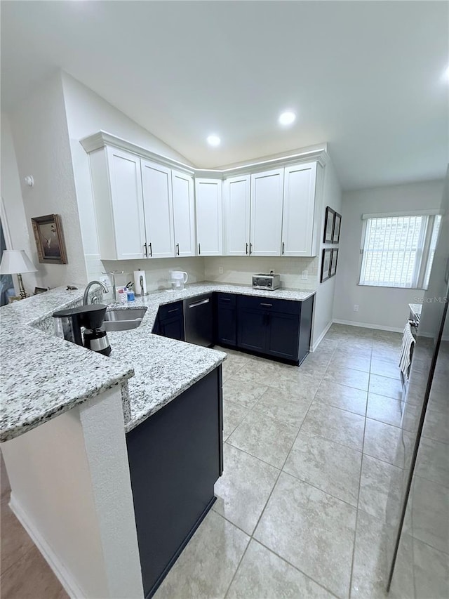 663 Jamaica Cir, Lakeland, FL 33803 - kitchen with a peninsula, light stone countertops, white cabinetry, lofted ceiling, and dishwasher