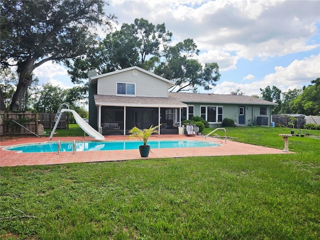 2014 Nancy Ave, Lutz, FL 33548 - back of house with a sunroom, a fenced backyard, a shingled roof, and a chimney