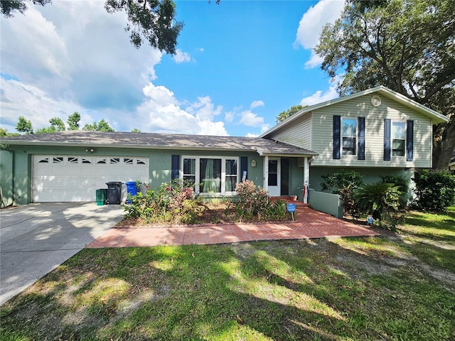 2014 Nancy Ave, Lutz, FL 33548 - tri-level home with an attached garage, concrete driveway, a front lawn, and stucco siding