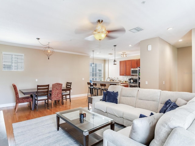4503 Legacy Park Dr, Tampa, FL 33611 - living area with a ceiling fan, light wood-style floors, plenty of natural light, crown molding, and recessed lighting