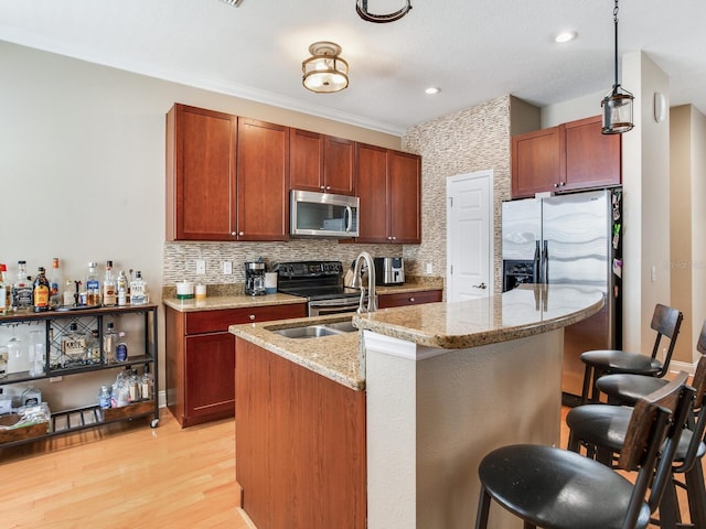 4503 Legacy Park Dr, Tampa, FL 33611 - kitchen with appliances with stainless steel finishes, a breakfast bar, backsplash, light wood finished floors, and light stone countertops
