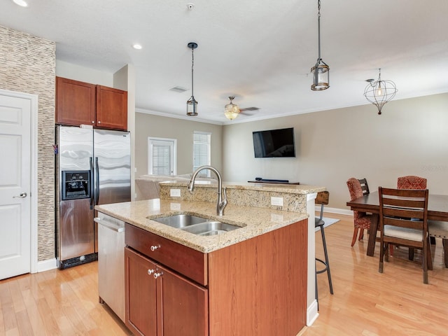 4503 Legacy Park Dr, Tampa, FL 33611 - kitchen with appliances with stainless steel finishes, a breakfast bar area, light wood finished floors, hanging light fixtures, and crown molding