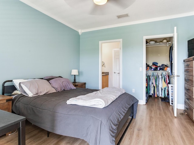4503 Legacy Park Dr, Tampa, FL 33611 - bedroom with a spacious closet, wood finished floors, ornamental molding, a closet, and ensuite bath