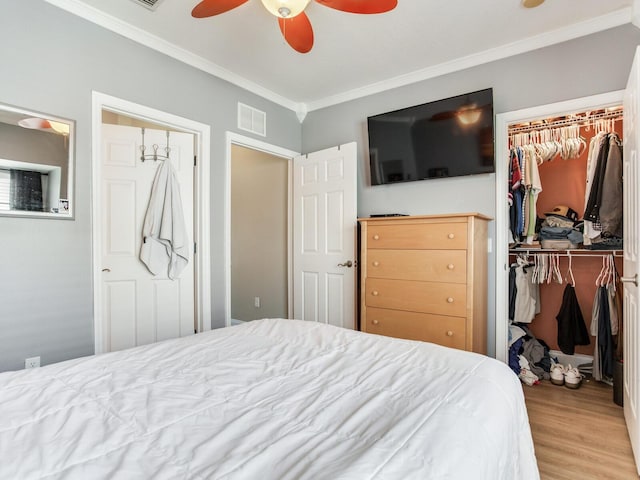 4503 Legacy Park Dr, Tampa, FL 33611 - bedroom with a walk in closet, crown molding, a closet, wood finished floors, and a ceiling fan