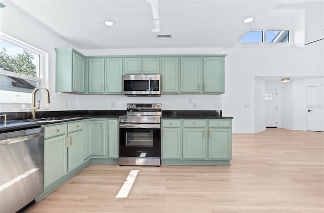 12106 Clearbrook Ct, Riverview, FL 33569 - kitchen with appliances with stainless steel finishes, green cabinetry, light wood-type flooring, and recessed lighting