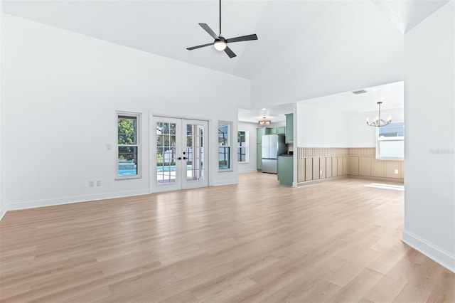 12106 Clearbrook Ct, Riverview, FL 33569 - unfurnished living room featuring french doors, high vaulted ceiling, light wood-type flooring, ceiling fan, and a chandelier