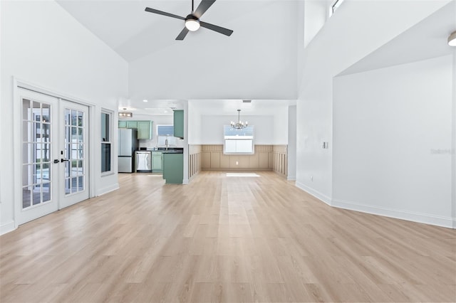 12106 Clearbrook Ct, Riverview, FL 33569 - unfurnished living room featuring high vaulted ceiling, a chandelier, french doors, light wood-style flooring, and a ceiling fan