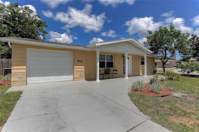 3707 Cambridge St, New Port Richey, FL 34652 - view of front of house featuring an attached garage, covered porch, and concrete driveway