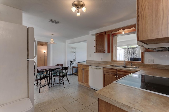 3707 Cambridge St, New Port Richey, FL 34652 - kitchen with white appliances, light tile patterned floors, brown cabinets, and light countertops
