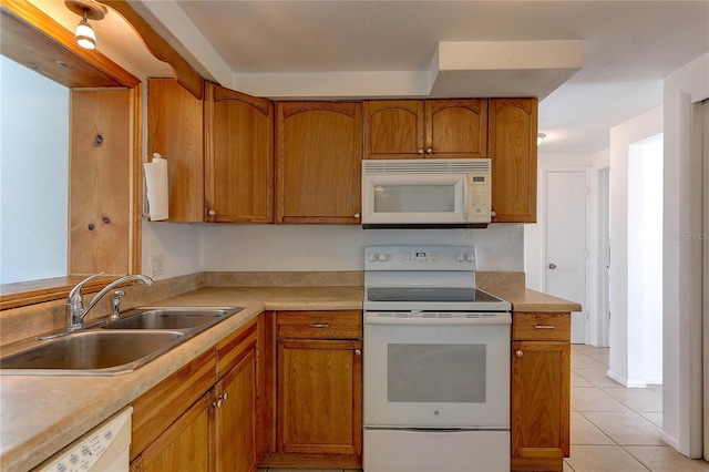 3707 Cambridge St, New Port Richey, FL 34652 - kitchen featuring white appliances, brown cabinets, light tile patterned floors, and light countertops