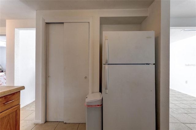 3707 Cambridge St, New Port Richey, FL 34652 - kitchen featuring freestanding refrigerator, light tile patterned flooring, and light countertops