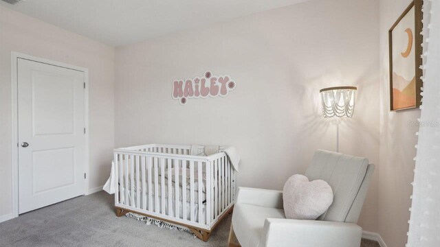 4350 Sand Dollar Way, Zephyrhills, FL 33541 - carpeted bedroom featuring a crib and baseboards