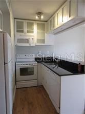 1301 S Howard Ave Unit C4, Tampa, FL 33606 - kitchen with white appliances, dark wood finished floors, and dark countertops