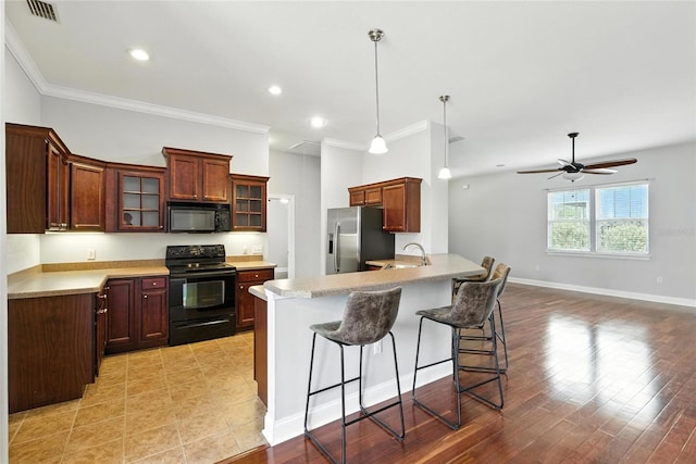16609 NW 166th Dr, Alachua, FL 32615 - kitchen featuring black appliances, a peninsula, ornamental molding, a kitchen breakfast bar, and glass insert cabinets