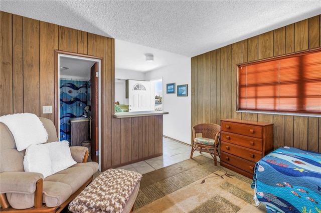 340 Bay Plz, Treasure Island, FL 33706 - bedroom with wood walls, a textured ceiling, and light tile patterned floors