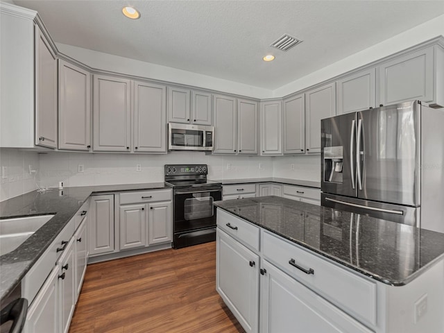 2812 Windcrest Oaks Ct, Valrico, FL 33594 - kitchen featuring stainless steel appliances, gray cabinets, recessed lighting, dark wood-style floors, and dark stone countertops