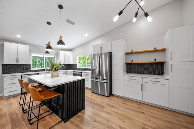 4639 Cabbage Palm Dr, Valrico, FL 33596 - kitchen featuring stainless steel appliances, backsplash, vaulted ceiling, a kitchen breakfast bar, and white cabinetry