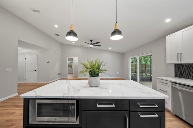 4639 Cabbage Palm Dr, Valrico, FL 33596 - kitchen with stainless steel appliances, vaulted ceiling, dark cabinetry, white cabinets, and light wood-style flooring