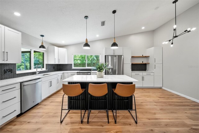 4639 Cabbage Palm Dr, Valrico, FL 33596 - kitchen with appliances with stainless steel finishes, decorative backsplash, vaulted ceiling, healthy amount of natural light, and white cabinets
