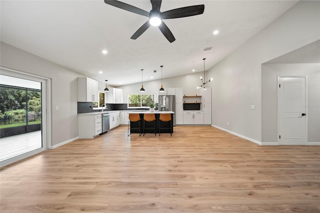 4639 Cabbage Palm Dr, Valrico, FL 33596 - kitchen featuring vaulted ceiling, appliances with stainless steel finishes, recessed lighting, a kitchen bar, and white cabinetry