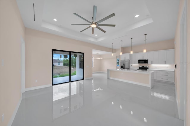 2606 34th St SW, Lehigh Acres, FL 33976 - unfurnished living room with a raised ceiling, a ceiling fan, and recessed lighting