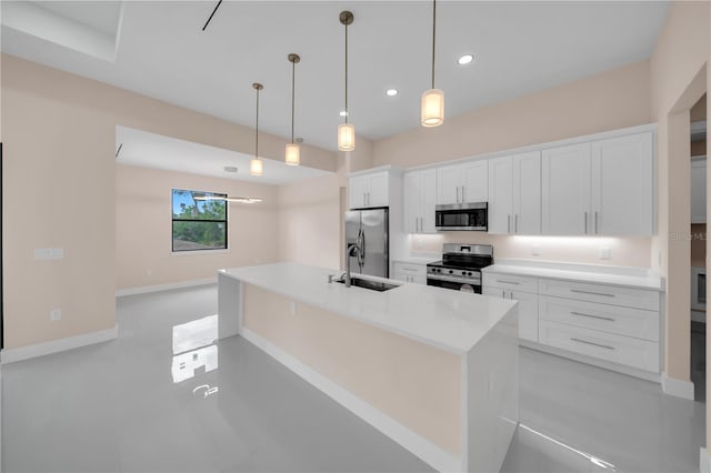 2606 34th St SW, Lehigh Acres, FL 33976 - kitchen featuring appliances with stainless steel finishes, white cabinets, a center island with sink, light countertops, and decorative light fixtures