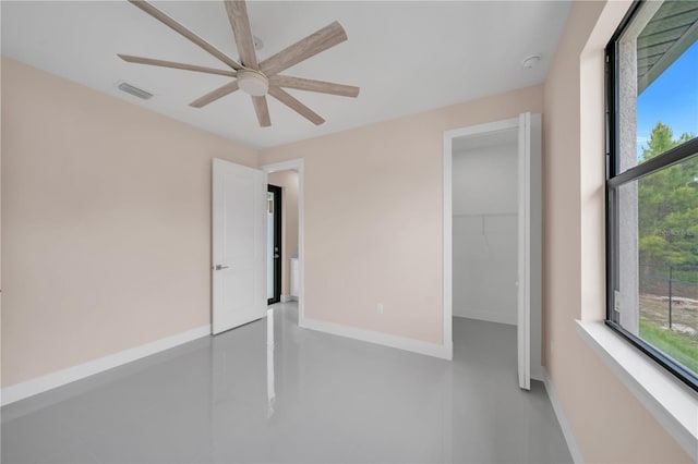 2606 34th St SW, Lehigh Acres, FL 33976 - unfurnished bedroom with a spacious closet, a ceiling fan, and a closet