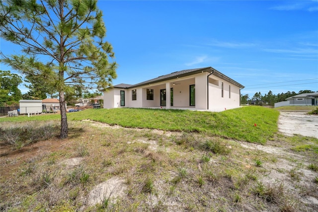 2606 34th St SW, Lehigh Acres, FL 33976 - back of property featuring stucco siding and a ceiling fan