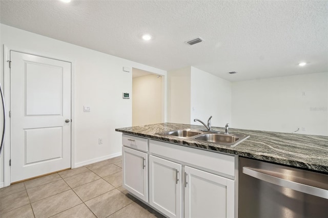 4119 Autumn Amber Dr, Spring Hill, FL 34609 - kitchen with stainless steel dishwasher, white cabinetry, a textured ceiling, dark stone counters, and light tile patterned floors