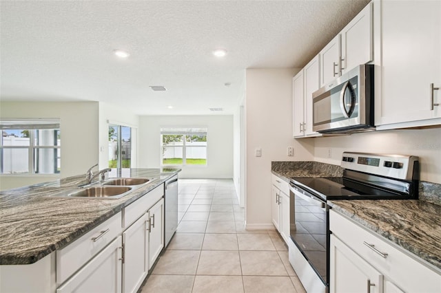4119 Autumn Amber Dr, Spring Hill, FL 34609 - kitchen featuring appliances with stainless steel finishes, white cabinetry, a textured ceiling, recessed lighting, and light tile patterned floors