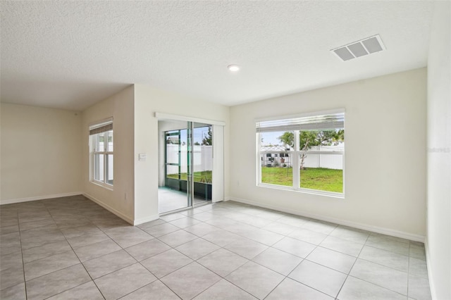4119 Autumn Amber Dr, Spring Hill, FL 34609 - unfurnished room featuring healthy amount of natural light, a textured ceiling, and light tile patterned floors