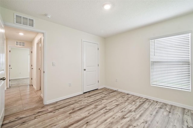 4119 Autumn Amber Dr, Spring Hill, FL 34609 - unfurnished room featuring light wood-type flooring, a smoke detector, a textured ceiling, and recessed lighting