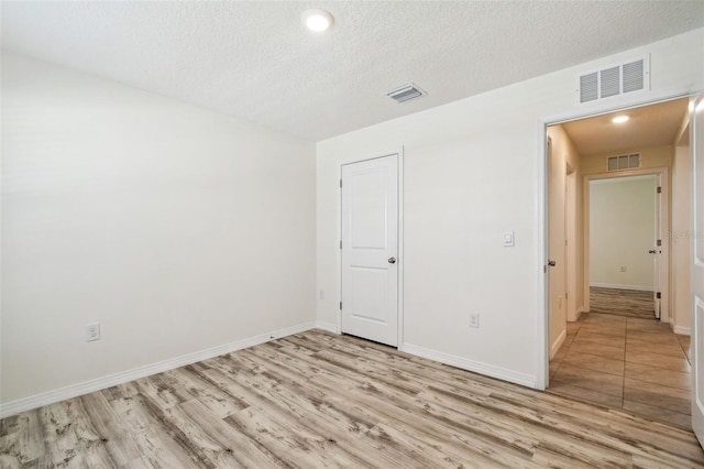 4119 Autumn Amber Dr, Spring Hill, FL 34609 - spare room with light wood finished floors, a textured ceiling, and recessed lighting