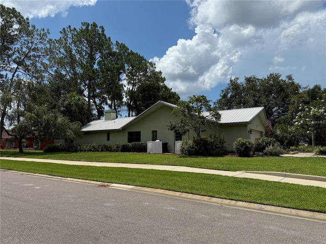 2215 Toniwood Ln, Palm Harbor, FL 34685 - view of side of home with a yard, an attached garage, and stucco siding