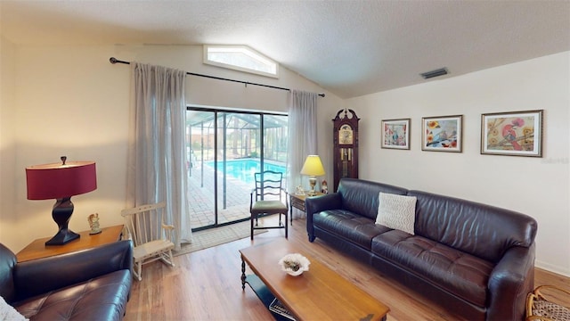 2215 Toniwood Ln, Palm Harbor, FL 34685 - living area with vaulted ceiling, wood finished floors, and a textured ceiling