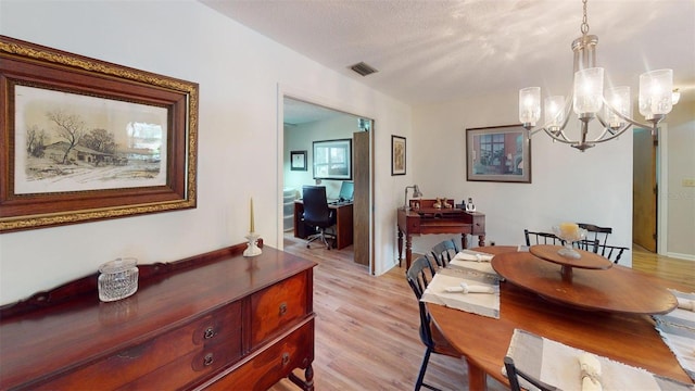 2215 Toniwood Ln, Palm Harbor, FL 34685 - dining space with a chandelier, light wood-style floors, a desk, and a textured ceiling
