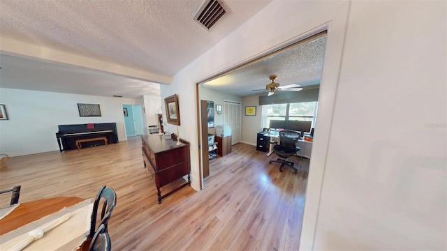 2215 Toniwood Ln, Palm Harbor, FL 34685 - home office with a textured ceiling, light wood-style flooring, and a ceiling fan